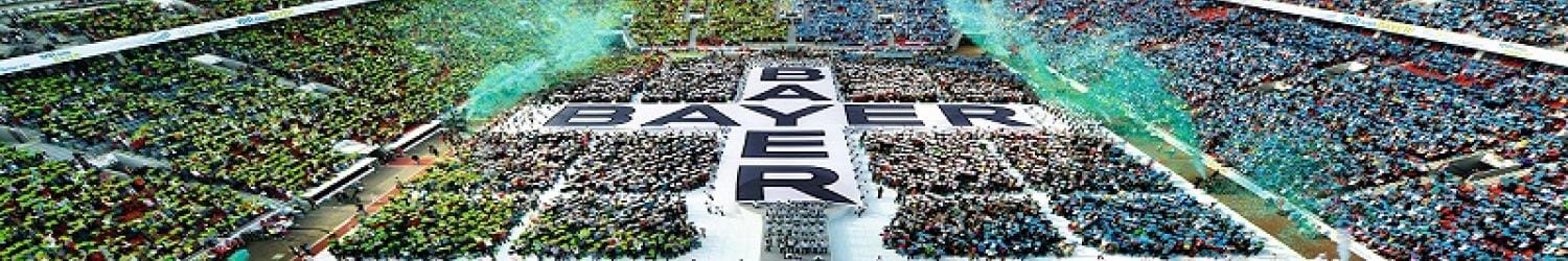 Stadium filled with people forming the word "BAYER" and the phrase "Science For A Better Life" on the field.