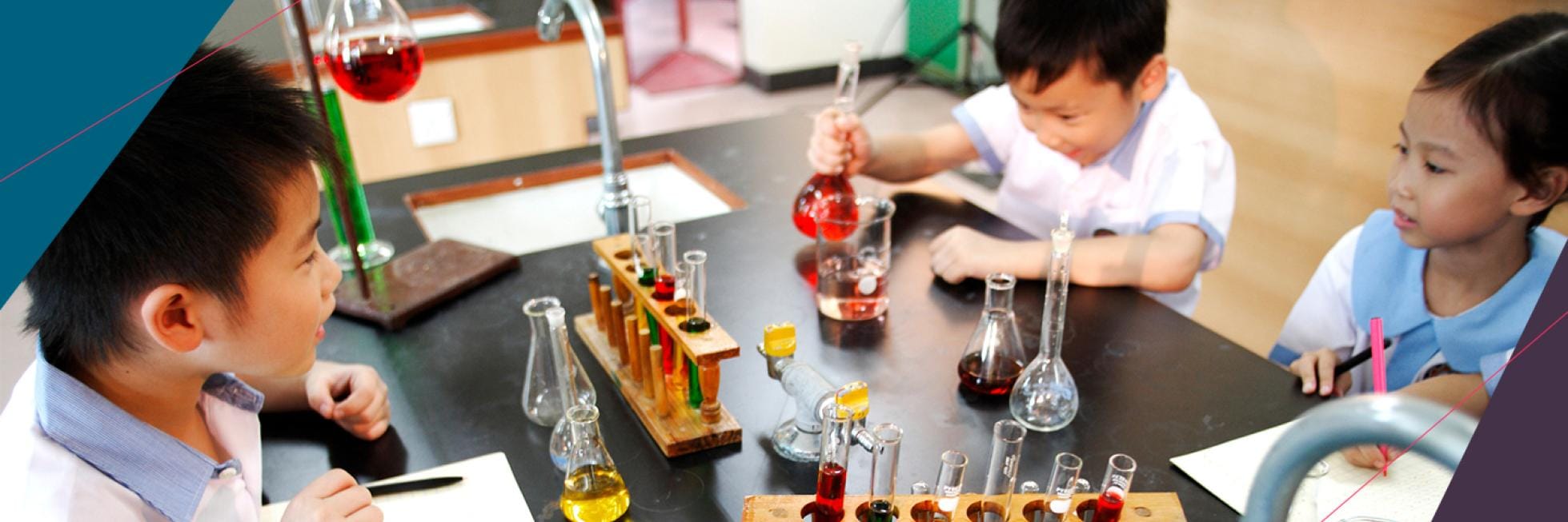 Three children in school uniforms conduct experiments with test tubes and beakers filled with colorful liquids at a laboratory table.